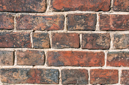 Brickwork on the wall of an old house built in the 19th century. The background is made of old brick. Full-bodied clay brick. Material for building construction.の写真素材