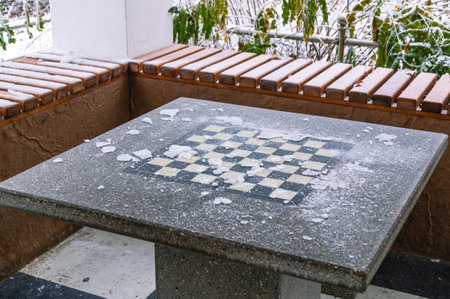 A game of chess. A house in the park for playing chess. A chessboard in the ice in the winter park....