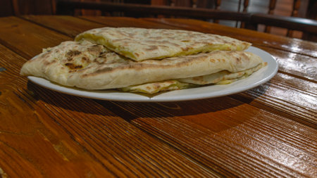 Fried pie with filling. Fried pancake made of dough with filling in a white plate on the table....