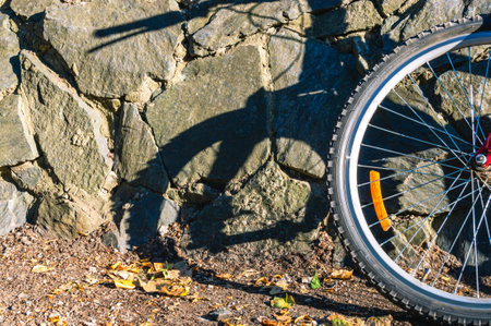 Bicycle wheel and stone wall. Active recreation by bike.の写真素材