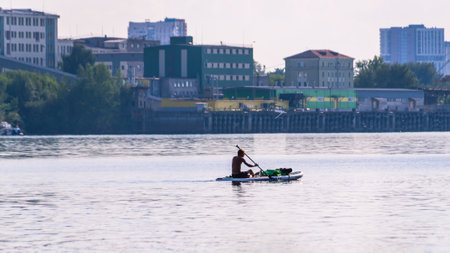 Active recreation on the board on the big river. Tourism on sap boards. outdoor water sports. A man...