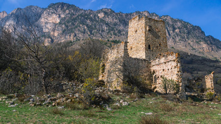 An ancient stone city in the Republic of Ingushetia. Historical structures for protection from attacks. Fortress towers made of stones against the background of mountains and blue sky.のeditorial素材