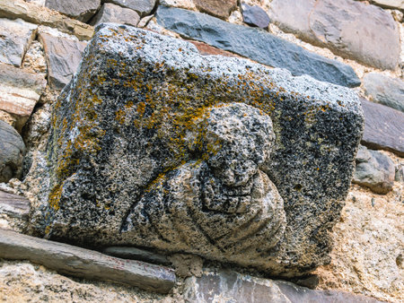The background of the masonry of the ancient temple. The image of a man on an ancient stone wall is an ancient stone wall with images that have undergone destructive erosion.の写真素材