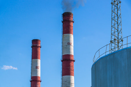 Black smoke comes out of the production high pipe. Industrial zone of the factory territory. Pipes...