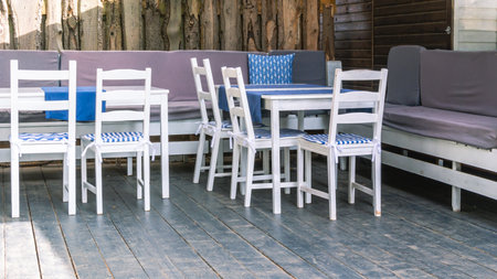 White wood furniture in the kitchen. Wooden furniture on the terrace of the house in summer. Rest in the village. Chairs and tables made of natural wood. Gazebo for sun protection with furniture.の写真素材
