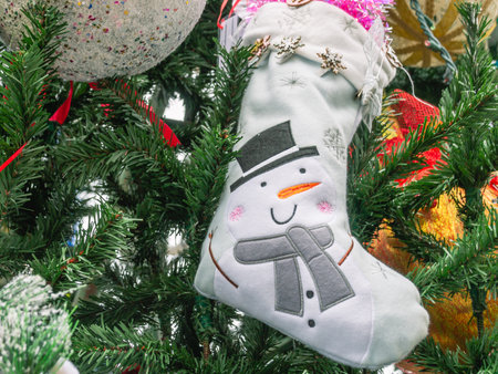 Christmas decoration, a white sock with the image of a snowman on the Christmas tree on the eve of...