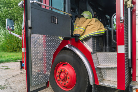 The open door of the fire truck cabin where the firefighters are located. A firefighter's protective...