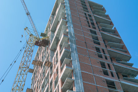 Installation of partitions and exterior walls made of red brick. The frame of a building under...