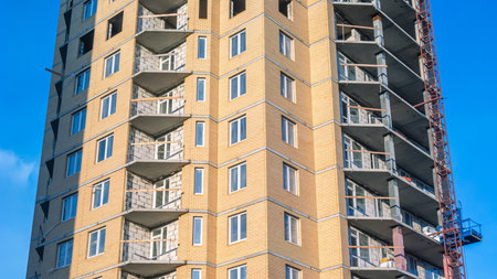 A mast lift lifts building materials for installation. A facade mast lift for lifting loads to the...