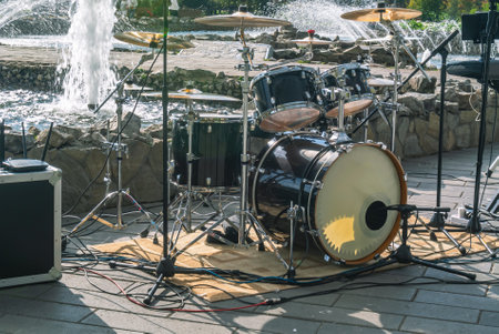 A set of percussion instruments used by one drummer. The drum kit at the fountain. Musical equipment of a musical group. An open-air concert. Drums and musical cymbals.の写真素材