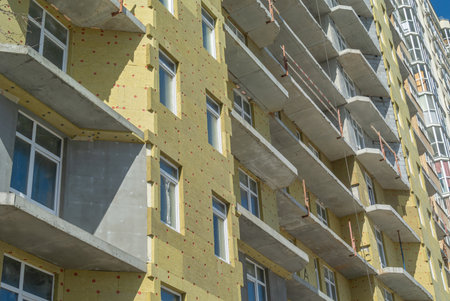 To keep warm in winter, soft insulation is installed on the exterior walls of the building. Laying of thermal insulation material on the walls. Insulation of the house. Plastering the walls.の写真素材