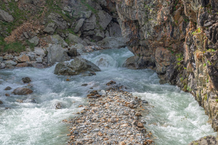 A river with clear water flows out of a mountain gorge. Environmentally friendly water flows down...