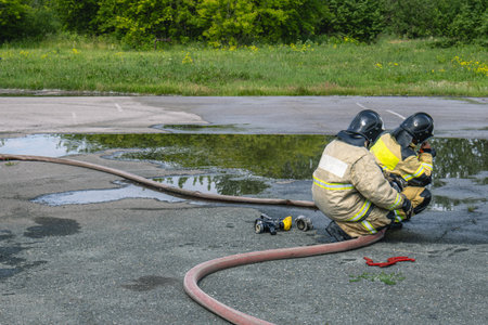 Firefighters hold a fire hose when high-pressure water is supplied. The fire extinguishing equipment...