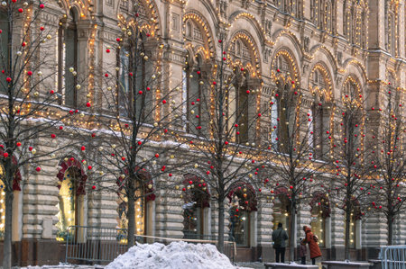 A festively lit old building on Christmas Eve. A family with a child stand in front of a lit...