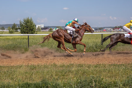 Horse racing at the racetrack. A horse led by a jockey. Horse riding competitions. A rider on a horse. Horses gallop along the racetrack track.の写真素材