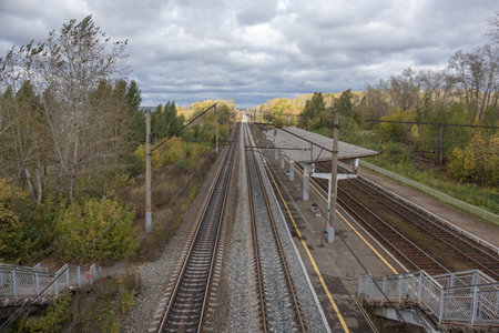 Railway station. The railway tracks pass through a small platform where people can board the...