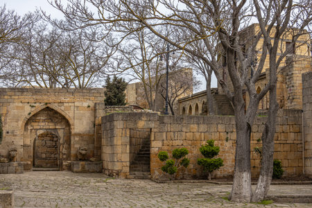 A courtyard with buildings made of stone blocks in the ancient city. Stone block walls and trees in a Persian fortress. Streets in an ancient fortress in the city of Derbent.の写真素材