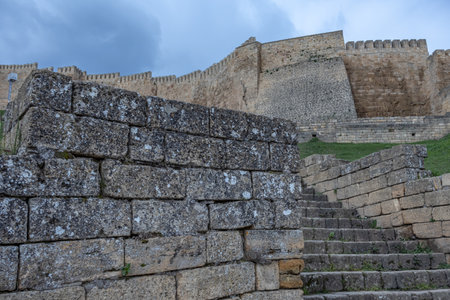 The walls of the ancient fortress are made of large stone blocks. View of the ancient Persian citadel. Ancient defensive structures. The high walls of the fortress in the Caucasus.の写真素材
