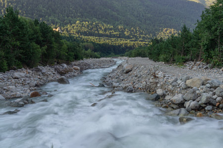 The bubbling glacial-clear water of a mountain river with large stones high in the mountains. Environmentally friendly water flows down from a glacier in the mountains. Nature in the mountains.の写真素材