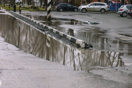 A puddle on a city street. A flooded road. Lack of drainage on the road. Incorrect drainage system design. Rainwater flooded the streets.の写真素材