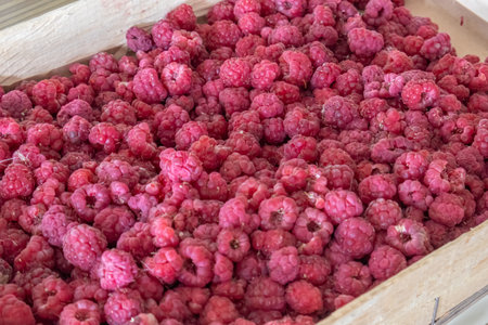 Raspberries in a small box. Berries contain vitamins and useful substances. Sweet edible raspberries...