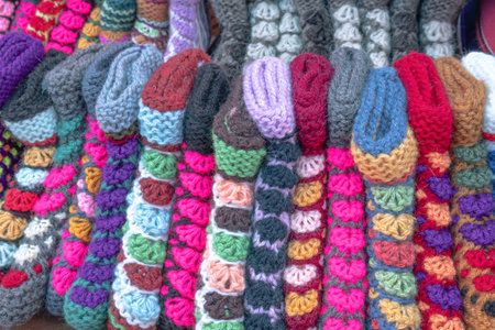 Knitted multicolored slippers made of natural wool. Multicolored handmade knitted socks. Warm...