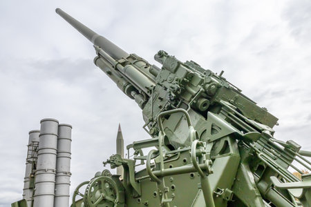 The barrel of a large-caliber cannon is aimed at the gloomy sky. Soviet and Russian artillery. A weapon for long-range strikes. Armed conflicts and wars.の写真素材