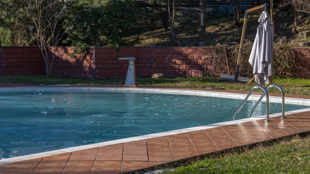 On a clear, frosty day, the outdoor pool was covered with a layer of ice. Pieces of ice on the...