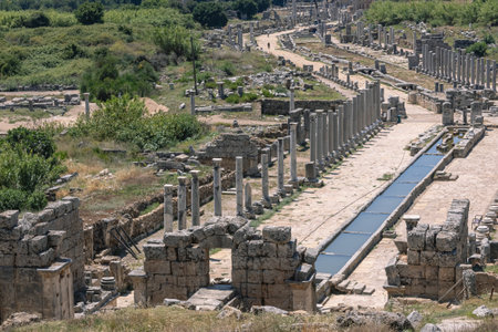View from the hill to the ruins of the ancient city of Perga. An ancient city located in Turkey. Columns and a water channel in an ancient city. History and culture of ancient civilizations.の写真素材