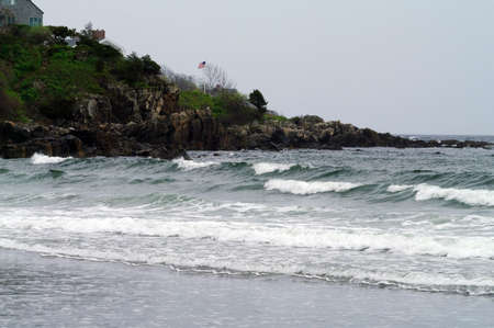 An American flag flying along the coast in Maine