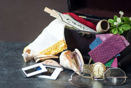 Memory Box Hankie on Left with shells, slides, watch, glasses, quilr pieces, and pipeの写真素材
