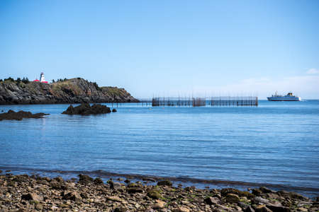 The Grand Manan V Ferry passing Swallowtail Lighthouse on the way into harbourの写真素材