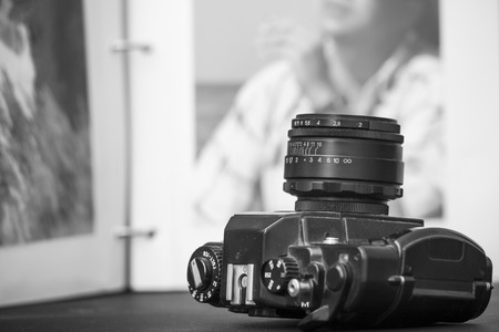 Old SLR camera on opened photo album backgroundの写真素材