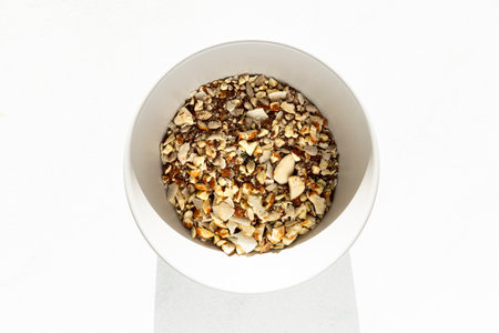 Chopped nuts in a bowl on a white background.の写真素材
