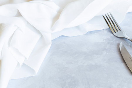 Fork and knife on a napkin on a gray background.の写真素材