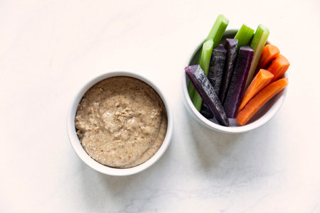 Vegetable hummus with carrots and celery in a bowl