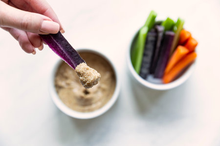 Vegetable sticks with dip in white bowls on a white backgroundの写真素材