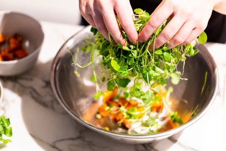 Close-up of woman's hands preparing vegetable salad, healthy food conceptの写真素材