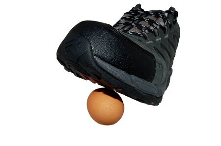 Men boot cracking egg closeupの写真素材