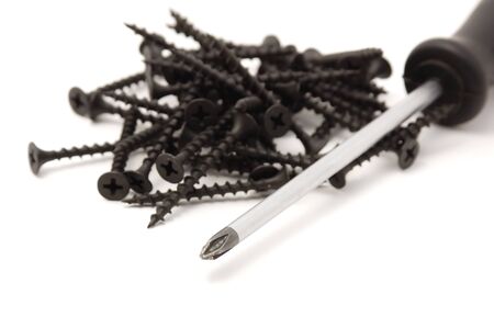 heap screws and screwdriver on the white backgroundの写真素材