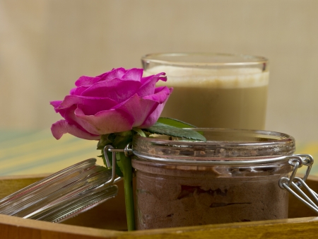 Chocolate pudding with a cup of coffee with milk and a pink roseの写真素材