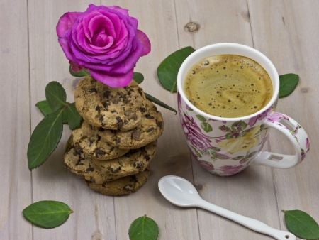 A cup of coffee with a stack of chocolate chip cookiesの写真素材
