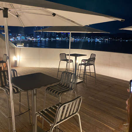Cafe at night on the background of the sea and the cityの写真素材