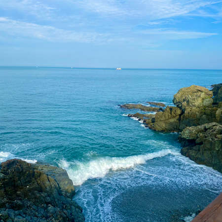 Beautiful seascape with waves crashing on the rocks and blue skyの写真素材