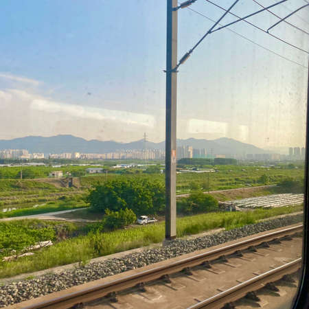 View from the train window to the city, cityscape and mountainsの写真素材