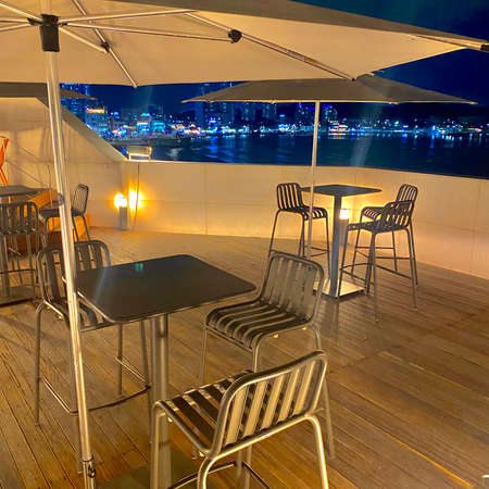 Night view of a restaurant terrace with tables and chairs at the beachの写真素材