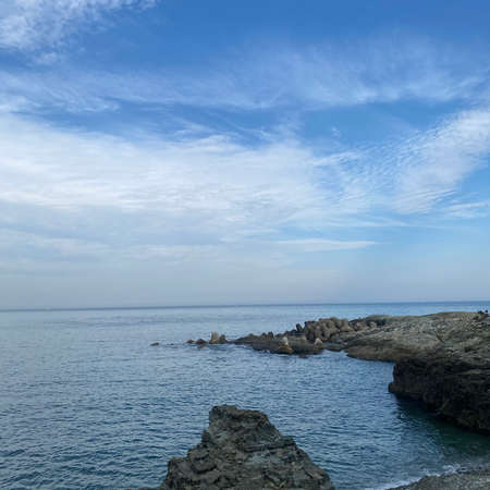 Rocky coast of the Black Sea against a blue sky with white clouds.の写真素材