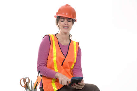 woman performs calculations wearing a construction outfit.の写真素材