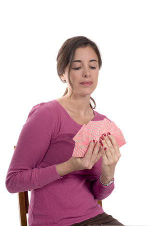 A Caucasian woman sits with a hand of cards.のeditorial素材