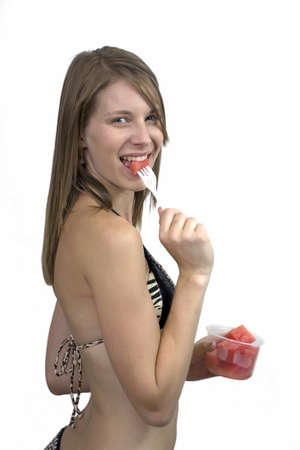 Girl eating watermelon indoors.  の写真素材
